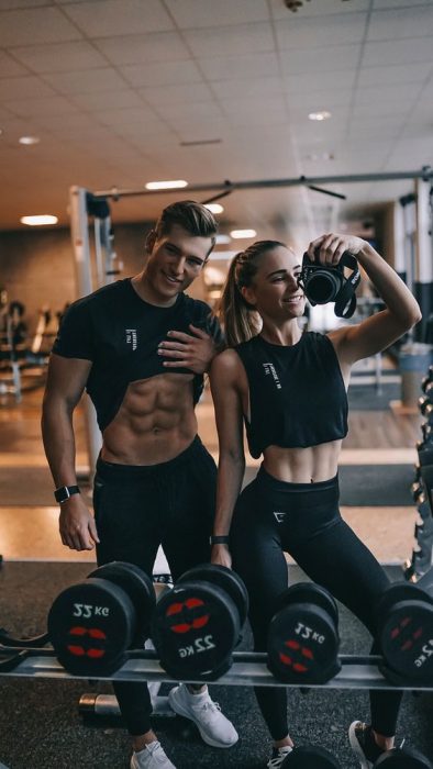 Pareja joven tomándose fotos en el gym