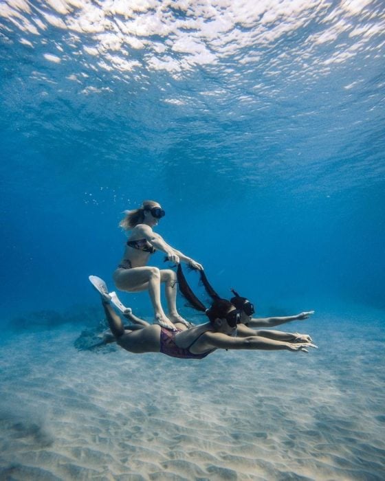 Chicas buzeando en el fondo del mar y dando la ilusión de que una está montando a otra como si se tratara de un delfín 