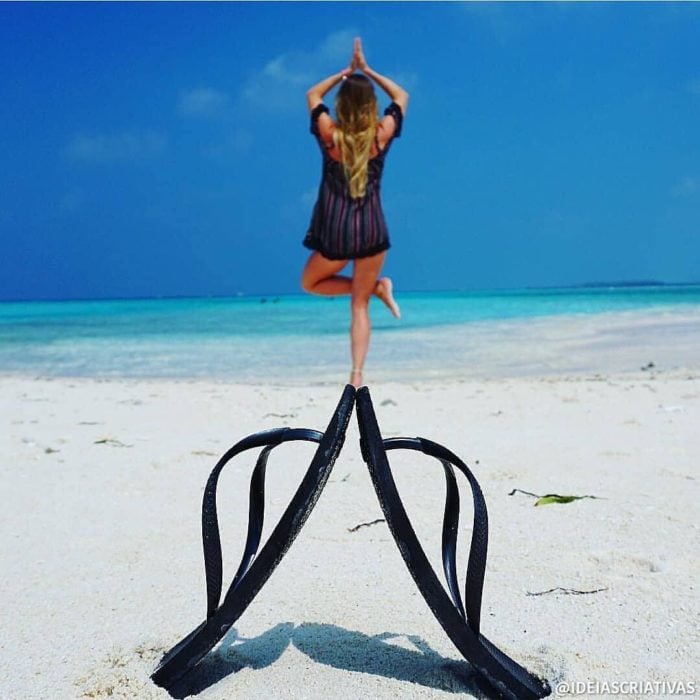 Chica haciendo yoga mientras está dando el efecto de que está parada sobre un par de chancletas 