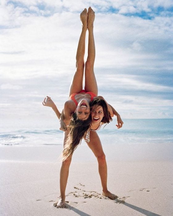 Foto de mejores amigas en la playa practicando Yoga en la playa