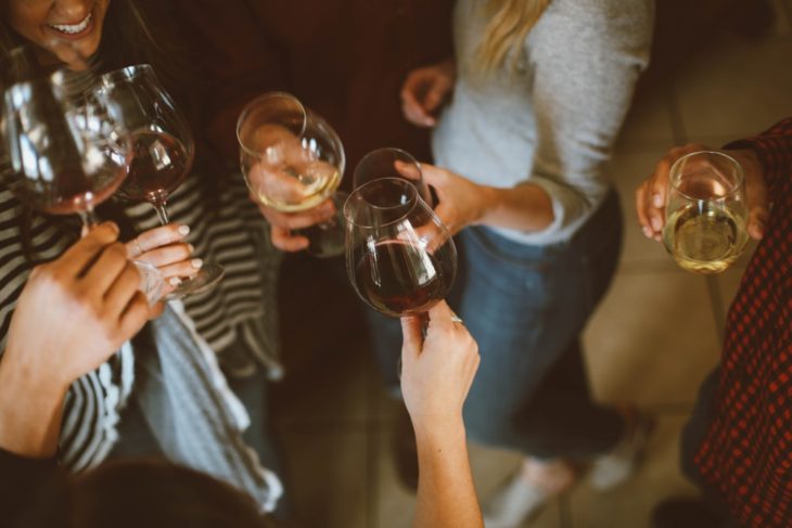 mujeres brindando, chocando sus copas de vino tinto durante una celebración