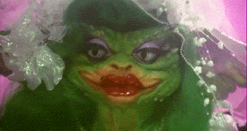 Gremlin hembra de la película Gremlins, criatura verde parecida a un duende con orejas puntiagudas con maquillaje cargado y velo de novia
