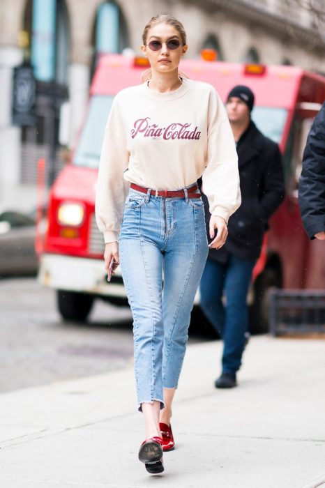 Gigi Hadid llevando pantalones de tiro alto con zapatos de tacón y camisa blanca 