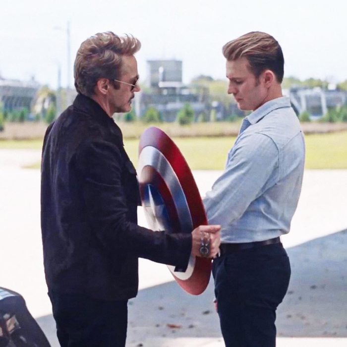 Chris Evans y Robert Downey Jr. charlando mientras sostienen el escudo de Capitán América, Avengers