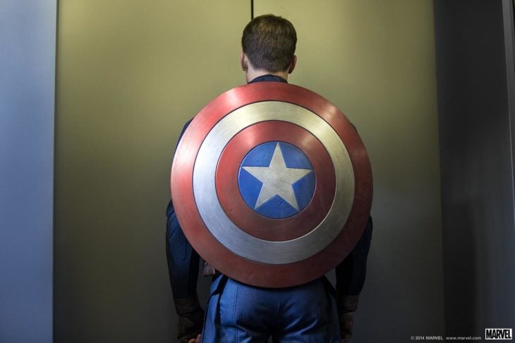 Capitán América de espaldas, mostrando su escudo, esperando el elevador, Chris Evans