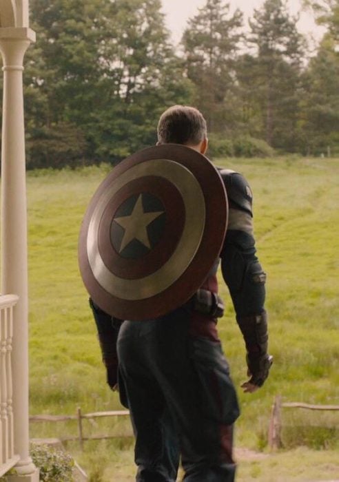 Capitán América de espaldas, mostrando su escudo, parado frente a una casa, Chris Evans