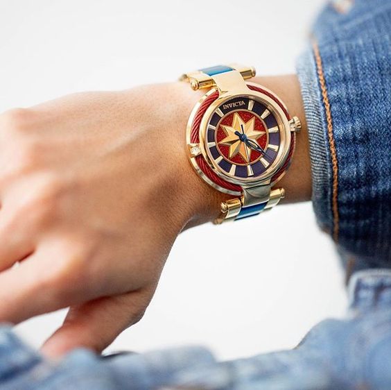 Reloj metálico con decoraciones en azul marino, rojo y amarillo, joyería inspirada en Marvel 