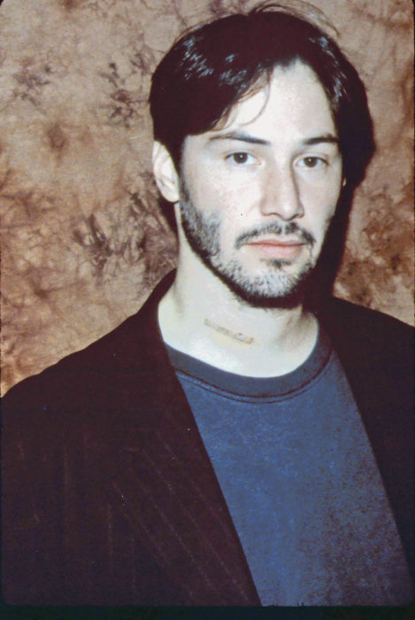 Actor Keanu Reeves joven; hombre de cabello corto con poca barba, con saco y playera