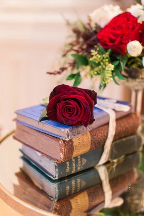Ideas para quinceañera estilo La Bella y la Bestia de Disney; libros antiguos con una rosa encima
