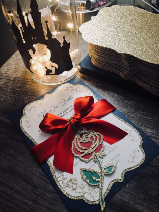 Ideas para quinceañera estilo La Bella y la Bestia de Disney; invitaciones con rosa y moño rojo