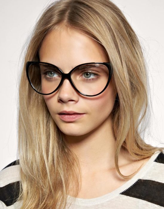 Cara Delevigne mostrandos sus lentes anchos de color negro 