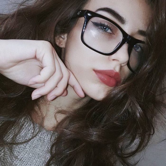 Chica posando para una selfie en la que muestra sus lentes de color negro