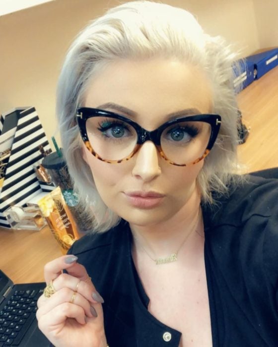 Chica posando para una selfie en la que muestra sus gafas de color negro con animal print