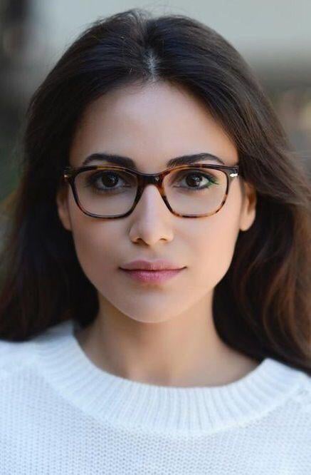 Chica posando para una foto mientras enseña sus pequeños lentes cuadrados de color café