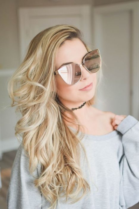 Chica modelando sus gafas claras con efecto de ojos de gato