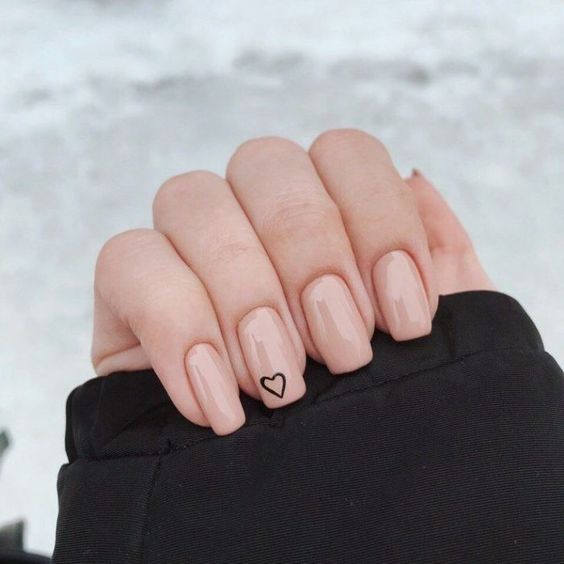 Mano de una chica con uñas cuadradas y en tono rosa pastel