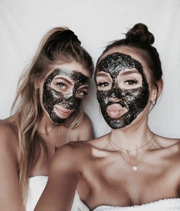 amigas usando mascarillas negras con glitters