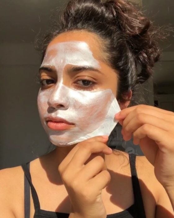 Chica removiendo una mascarilla facial de su rostro