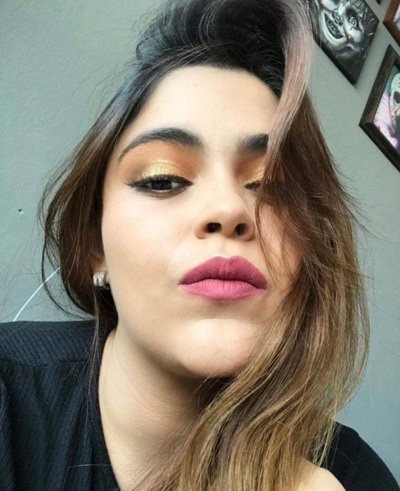 Chica ayuda a su mejor amiga a maquillarse vía Whatsapp; selfie de mujer con maquillaje de día, sombras anaranjada y amarilla, labial rosa