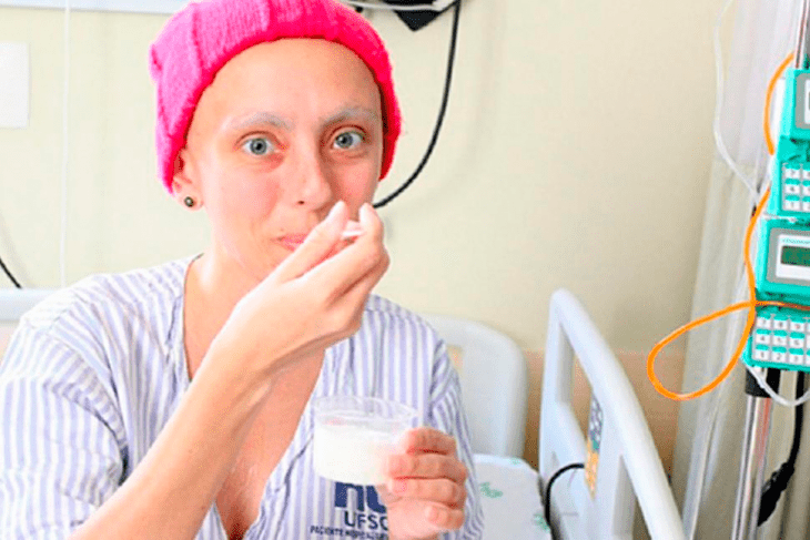 mujer enferma con gorra rosa comiendo helado