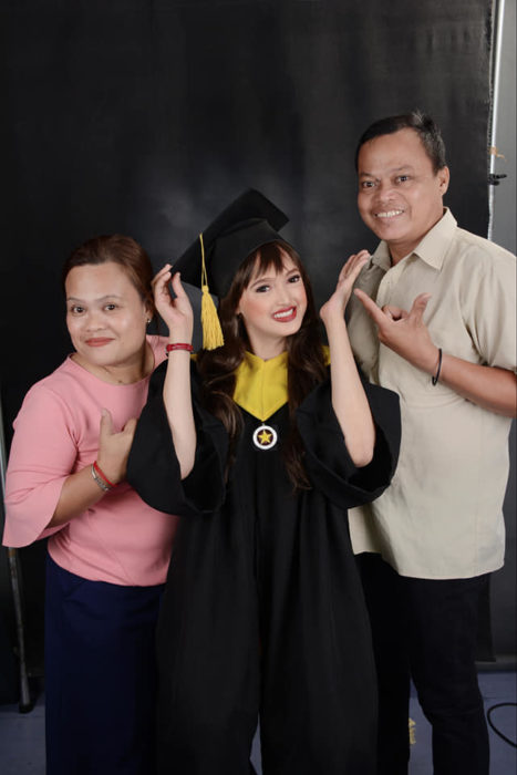 Patricia Banzuela, chica con alopecia el día de su graduación parada junto a sus padres en la foto del recuerdo 