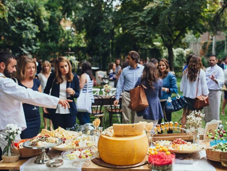 Personas caminando en una boda mientras ven qué comida elegir del buffet