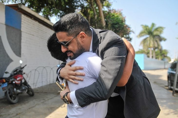 Empresario árabe, Yaqoob Yusuf Ahmed Mubarak abraza a Victor Martín Angulo Córdoba, niño peruano que hace la tarea bajo un poste de luz