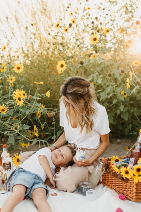 Cosas graciosas que dicen los niños; mamá e hijo en un picnic, son flores amarillas en el fondo y una canasta con comida
