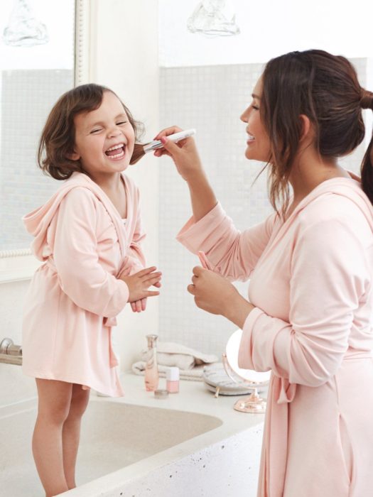 Cosas graciosas que dicen los niños; mamá e hija con batas rosas que combinan, mujer maquillando a niña