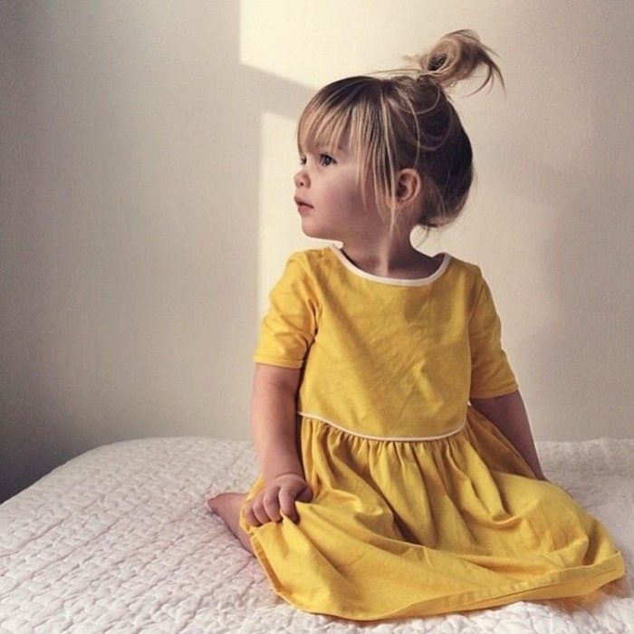 Cosas graciosas que dicen los niños; nila rubia con vestido amarillo sentada