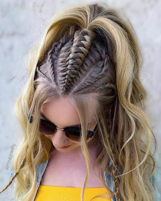 Chica mostrando sus trenzas que terminan en una coleta alta 