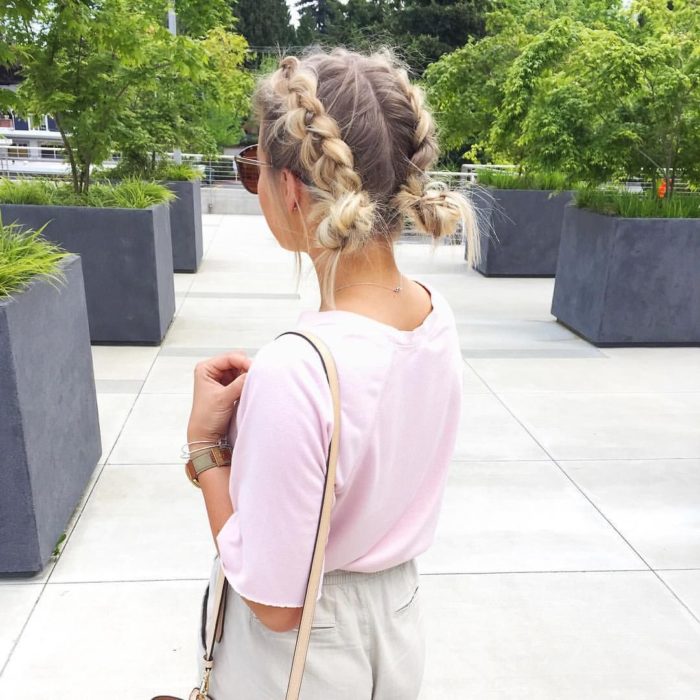 Ideas de peinados para el calor; chica rubia con dos trenzas y chongos