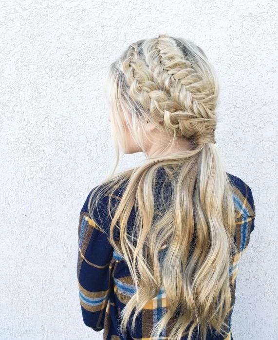 Ideas de peinados para el calor; chica de cabello largo y rubio peinada con dos trenzas diferentes y una cola de caballo baja