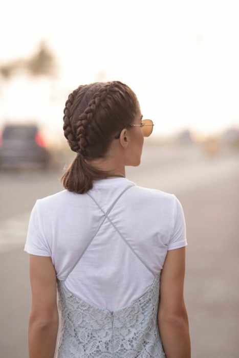 Ideas de peinados para el calor; chica de espaldas con el cabello castaño corto peinada con dos trenzas y una cola de caballo