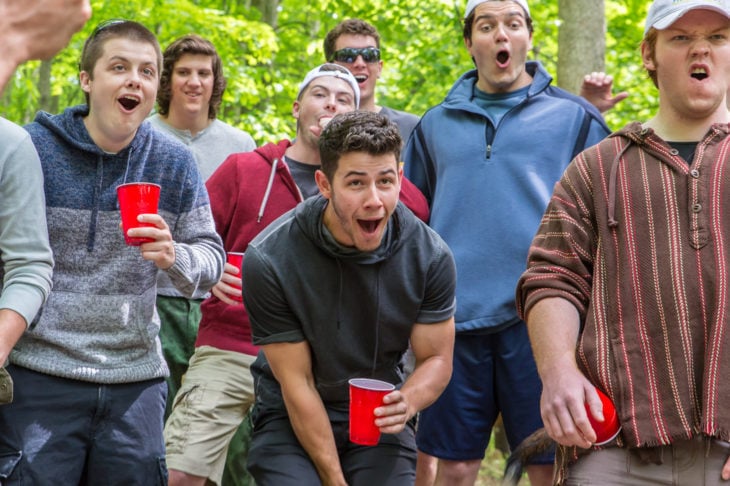Película La iniciación con Nick Jonas; grupo de estudiantes de fraternidad en una fiesta