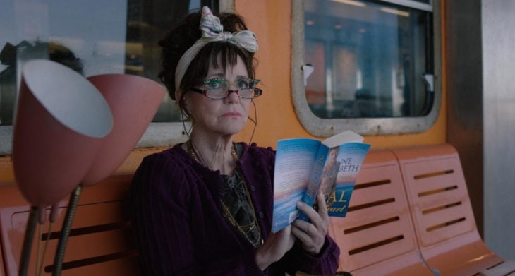 Película Mi nombre es Doris con actriz Sally Field; mujer mayor con lentes leyendo un libro en una banca