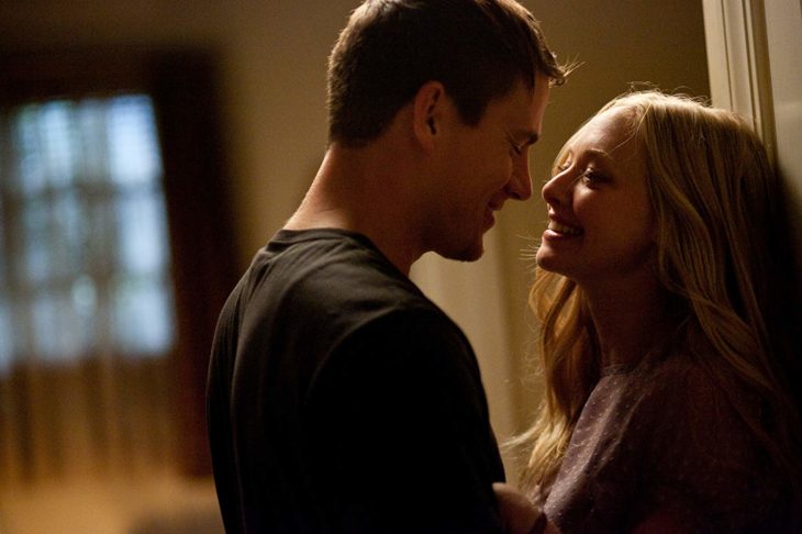 Channing Tatum y Amanda Seyfred dentro de una habitación mirándose de frente y sonriendo, escena de la película Querido John 