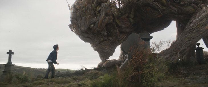 Lewis MacDougall fuera de parque viendo a monstruo creado co CGI, escena de la película Un monstruo viene a verme