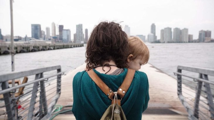 Ellen Page de espaldas cargando a una bebé en brazos sobre un muelle, escena de la película Tallulah 
