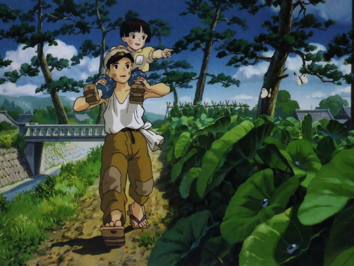 Dibujo animado de un niño japones cargando a su hermana de paseo por el bosque, escena de la película La tumba de las luciernagas, Studio Ghibli