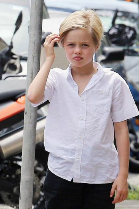 Shiloh Jolie Pitt caminando agarrando su cabeza