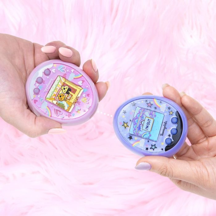 Anuncian regreso de Tamagotchi, la mascota virtual de los noventas; manos sosteniendo un tamagothci rosa y azul