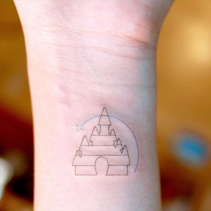 Tatuaje minimalista del castillo de Disney en la muñeca