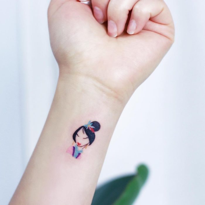 Tatuaje minimalista de Mulán de Disney en la muñeca