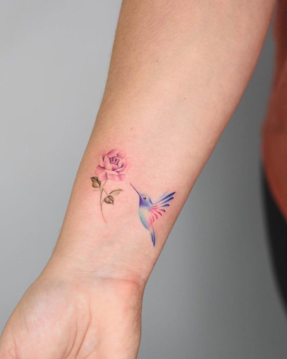 Diseño de tatuaje de colibrí que va a picar una flor 