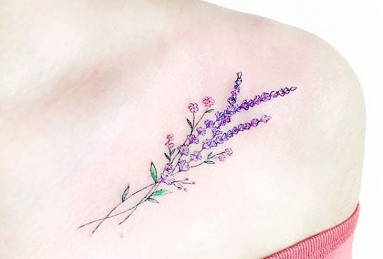 Diseño de tatuaje minimalista de flores violetas colocadas en el hombro 