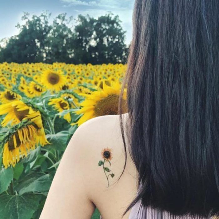 Diseño de un tatuaje minimalista de un girasol colocado en la espalda 