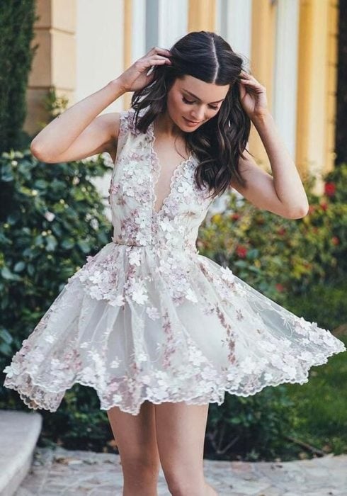 Chica usando un vestido corto en color blanco con aplicaciones florales 