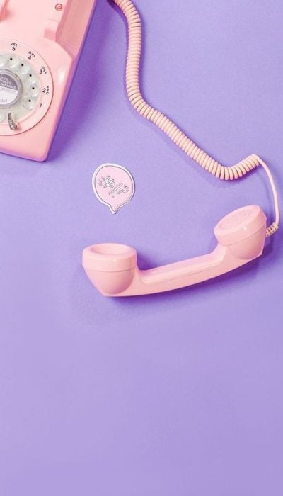 Fondo de pantalla para celular con un teléfono antiguo de color rosa pastel