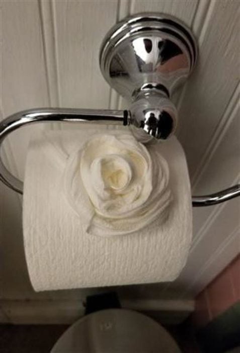 Rosa hecha con papel de baño y colocada sobre el rollo de papel 